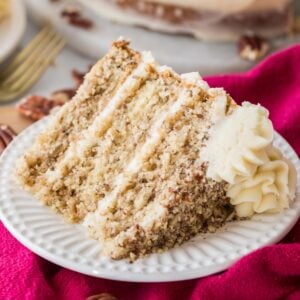 Slice of three layer butter pecan cake on a plate.