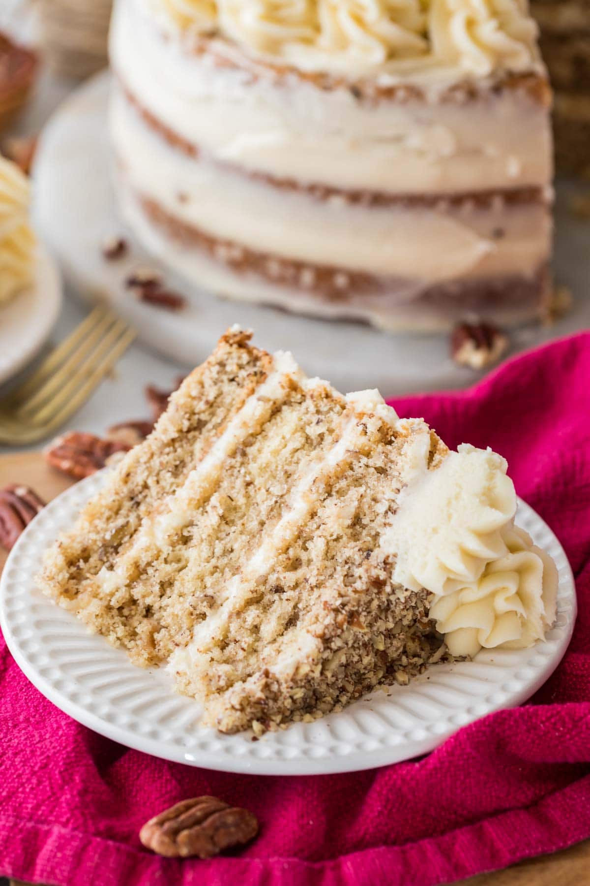 Slice of three layer butter pecan cake on a plate.