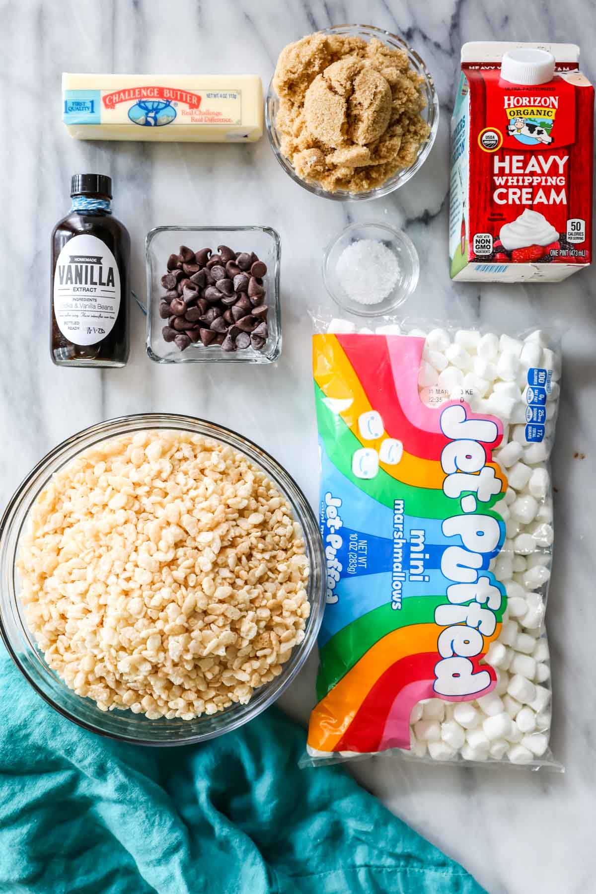 Overhead view of ingredients including rice krispies cereal, marshmallows, brown sugar, cream, and more.