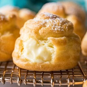 Close-up view of cream puffs filled with pastry cream and dusted with powdered sugar.