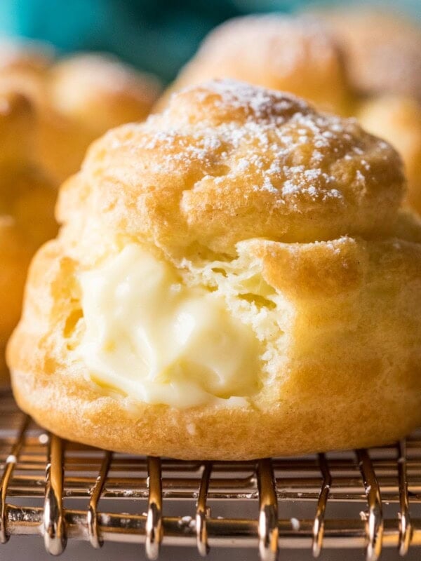 Close-up view of cream puffs filled with pastry cream and dusted with powdered sugar.