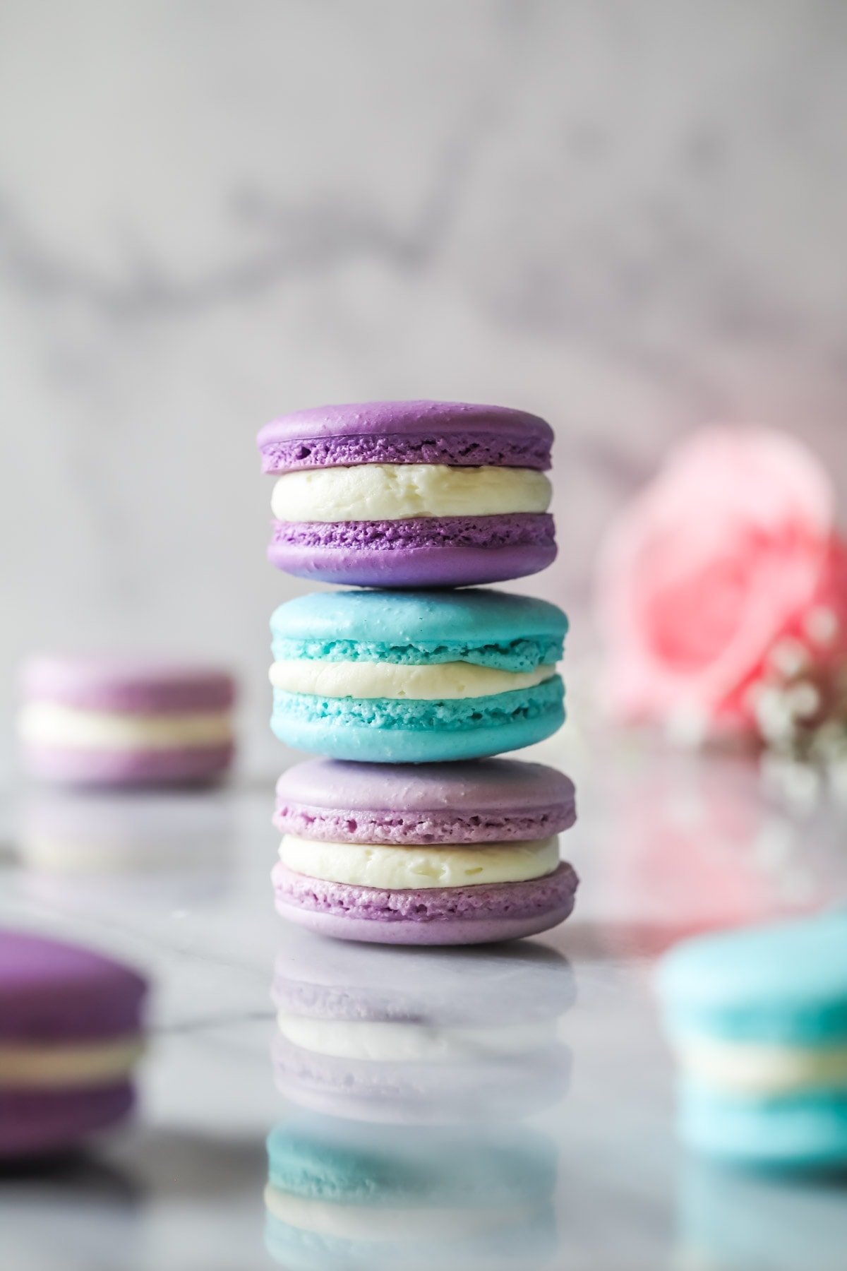 Three French macarons of different colors stacked on top of each other