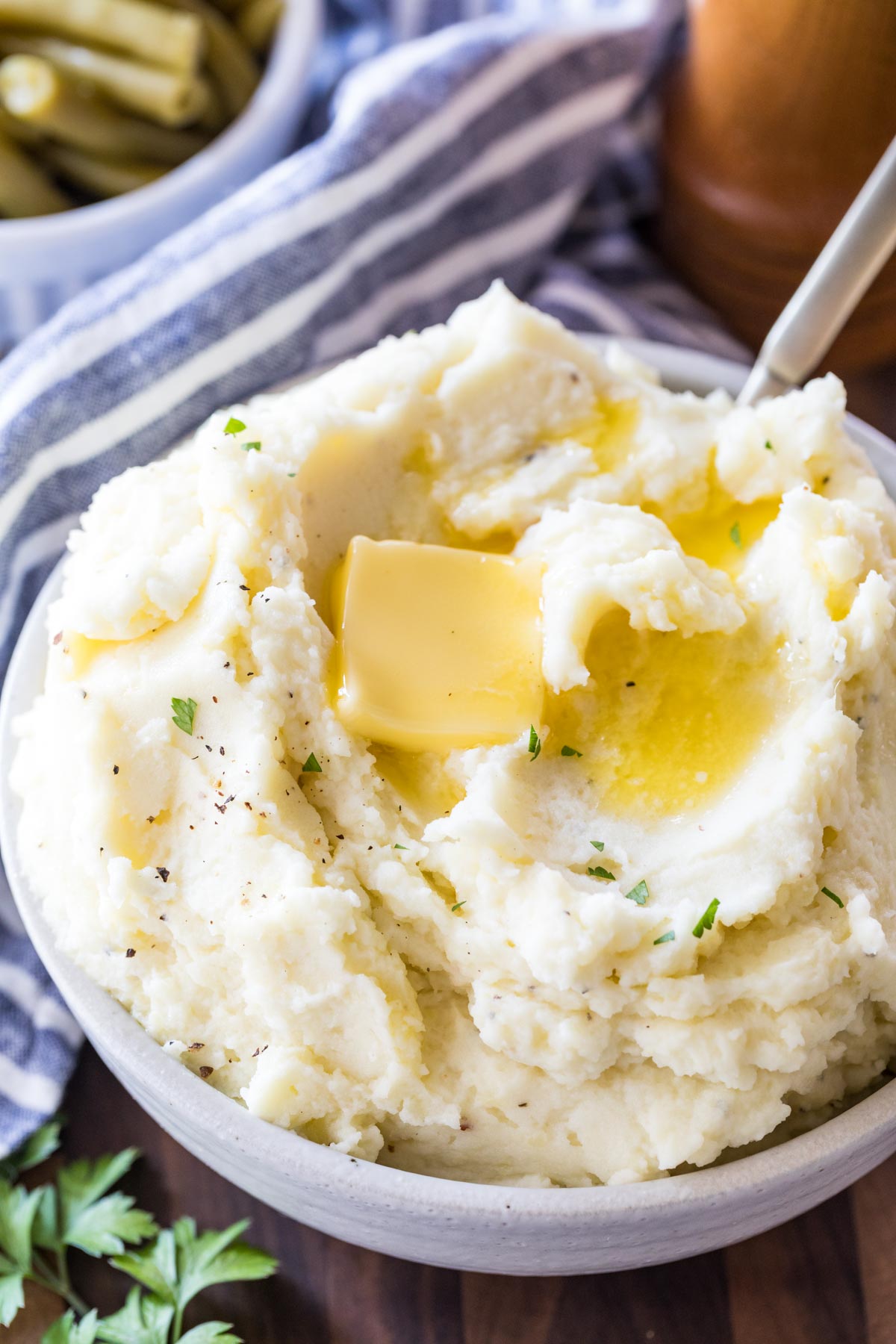 Mashed potatoes in a bowl with butter on top.