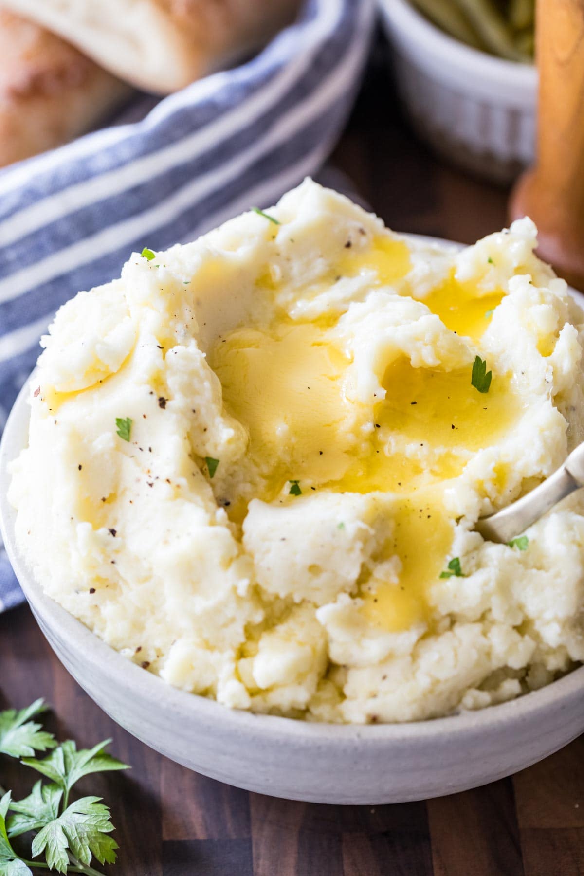 Large bowl of mashed potatoes with melted butter on top.