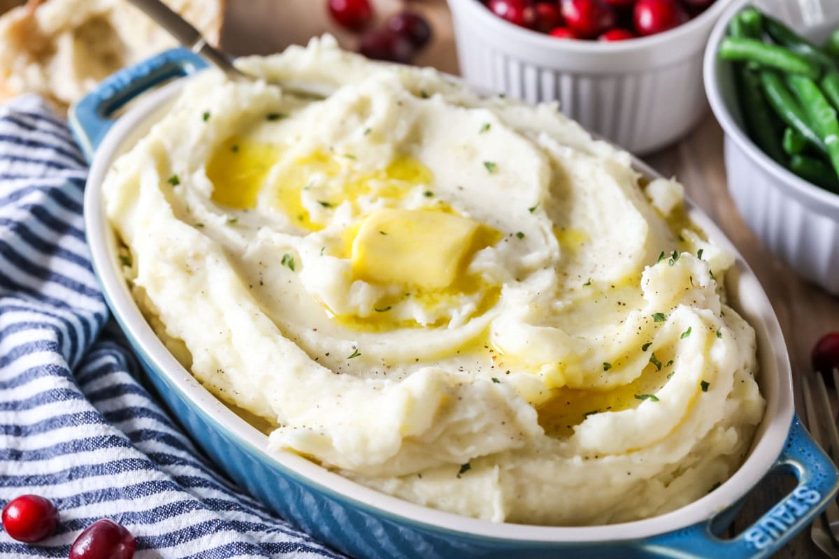 Serving dish of potatoes topped with butter.