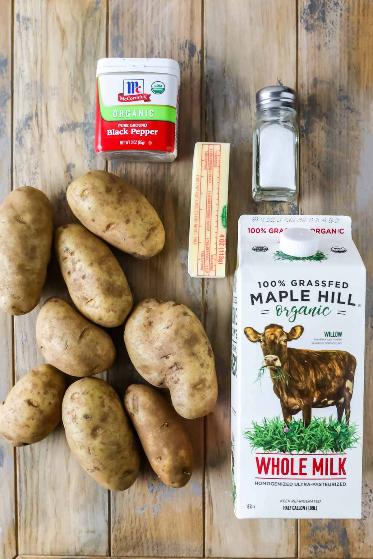 Overhead view of ingredients including potatoes, milk, salt, pepper, and butter.