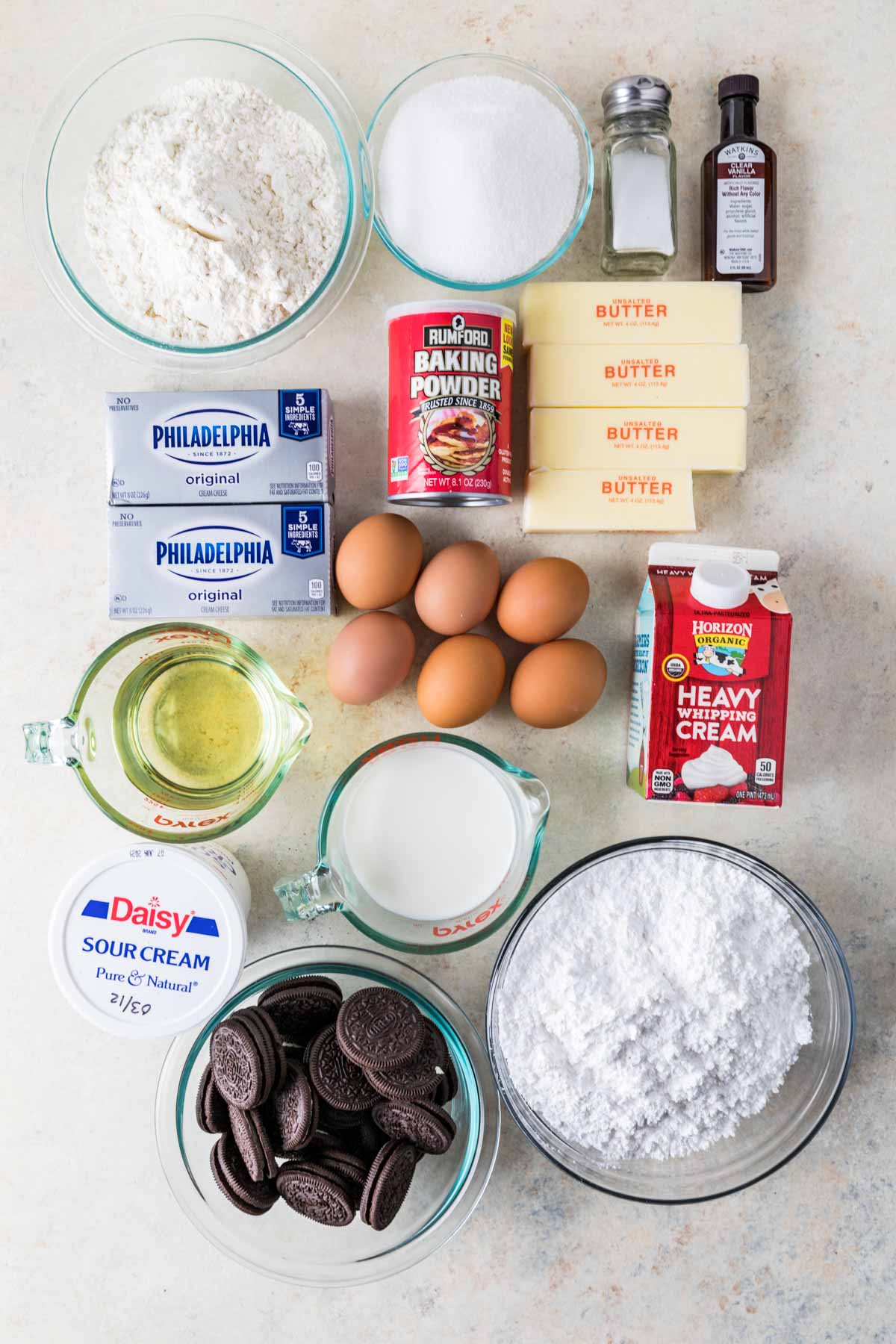 Overhead view of ingredients including flour, eggs, sour cream, oreos, and more.