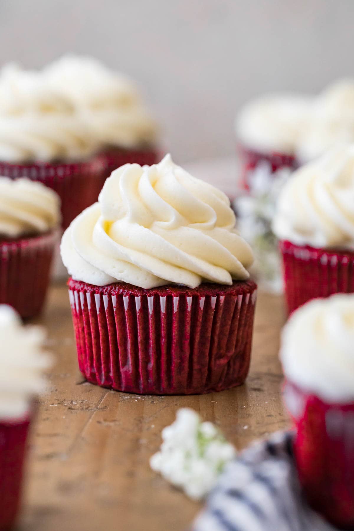 Red cupcakes topped with large piped swirls of ermine frosting.