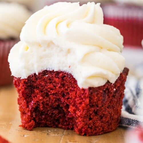 Red velvet cupcake with one bite missing.