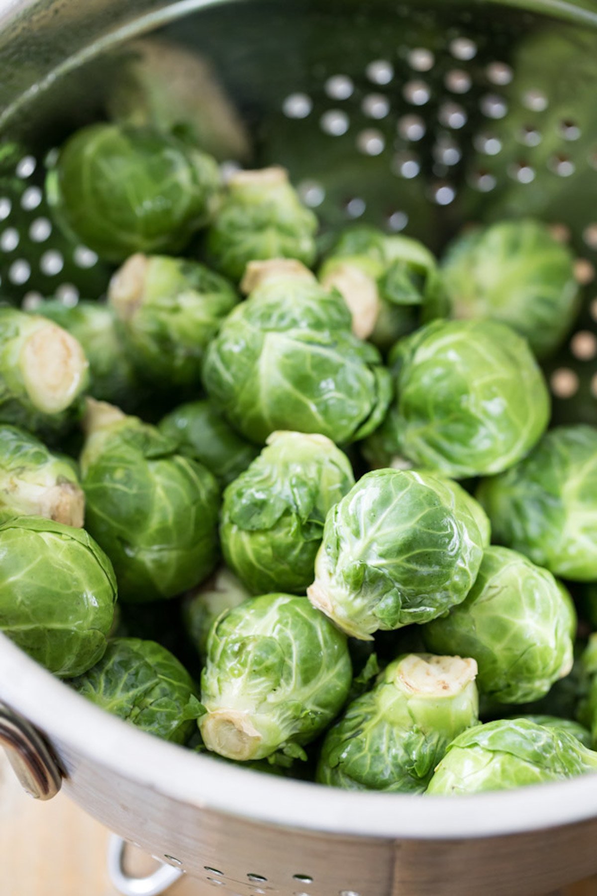 Whole brussels sprouts in a colander.