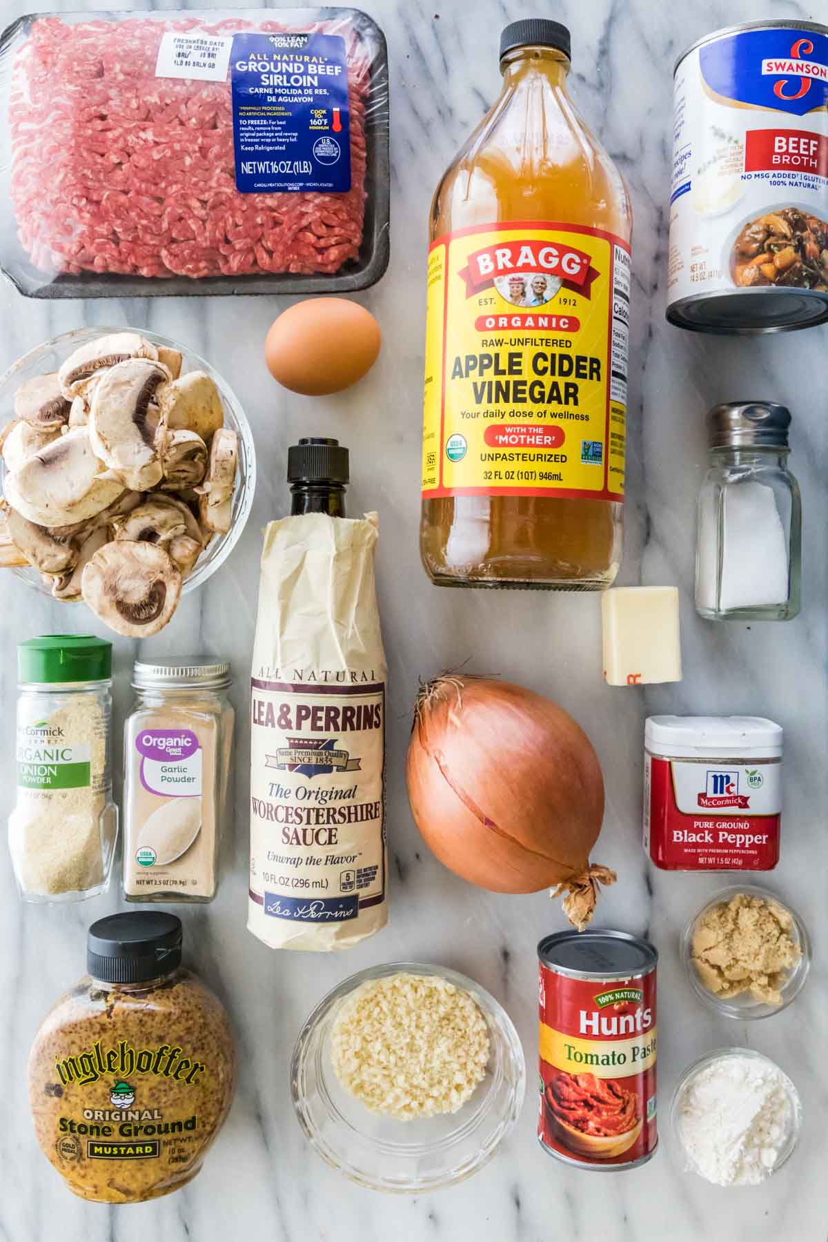 Overhead view of ingredients including ground beef, apple cider vinegar, mushrooms, and more.