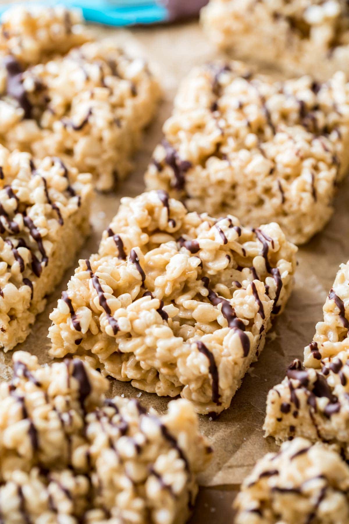 Close-up shot of salted caramel rice krispie treats lightly drizzled with dark chocolate.