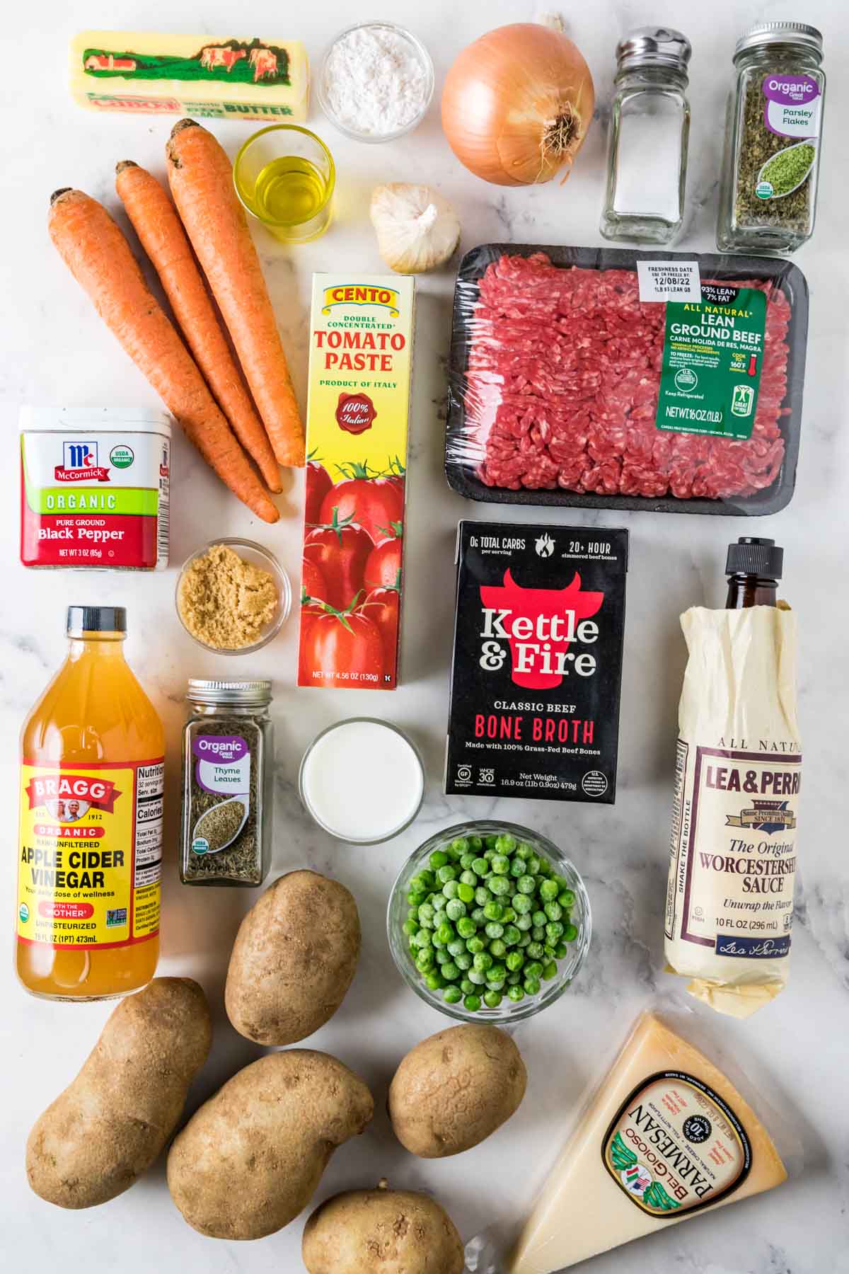 Overhead view of ingredients including carrots, peas, potatoes, ground beef, and more.