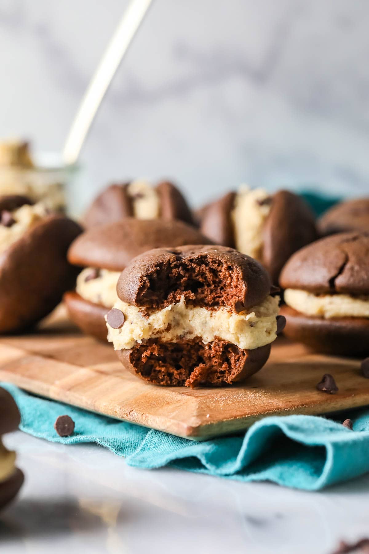 Chocolate whoopie pie with a cookie dough filling missing one bite.