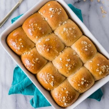 Overhead view of a pan of golden brown honey wheat rolls.