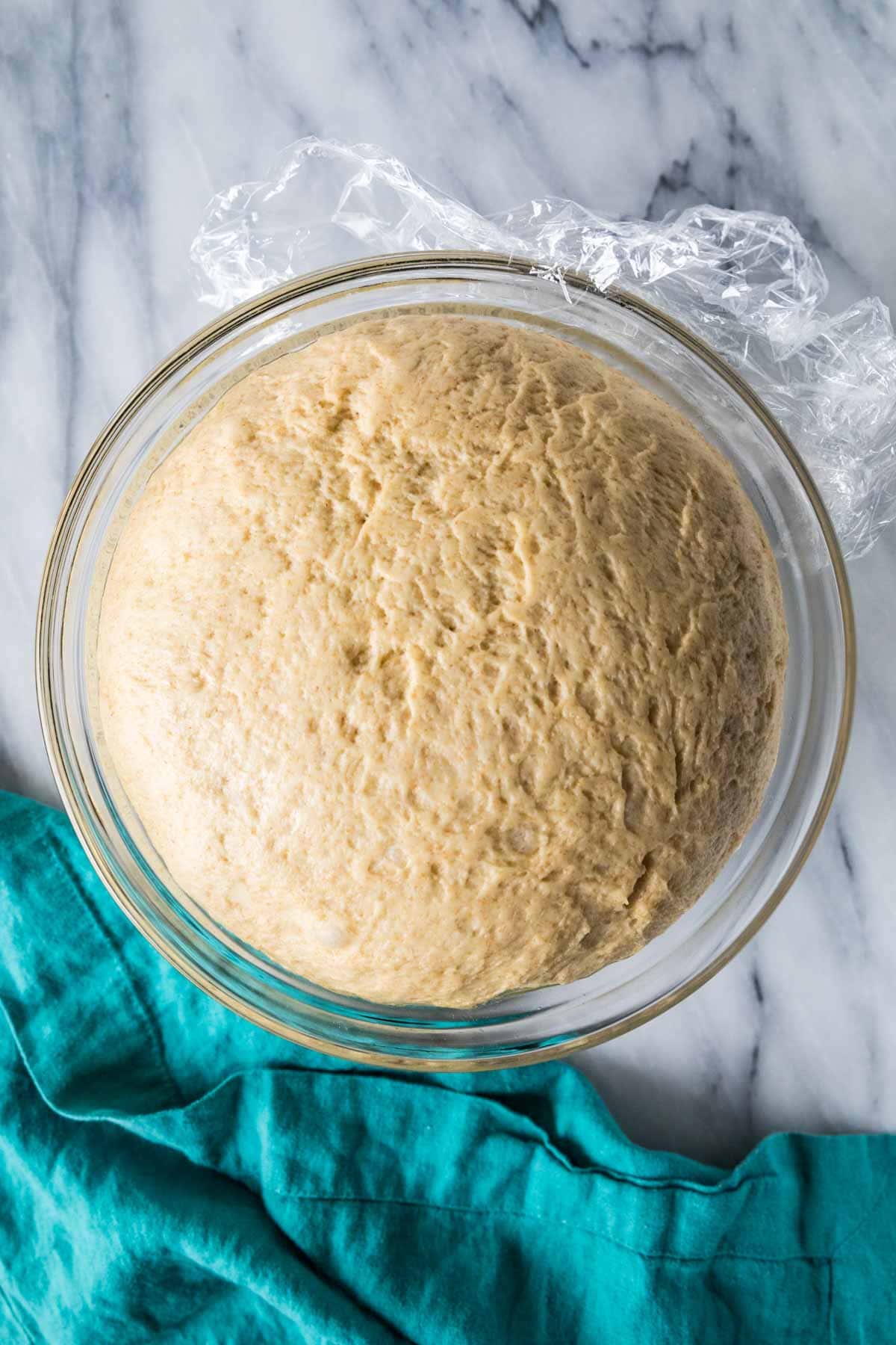 Overhead view of a honey wheat dough that has risen in a bowl.