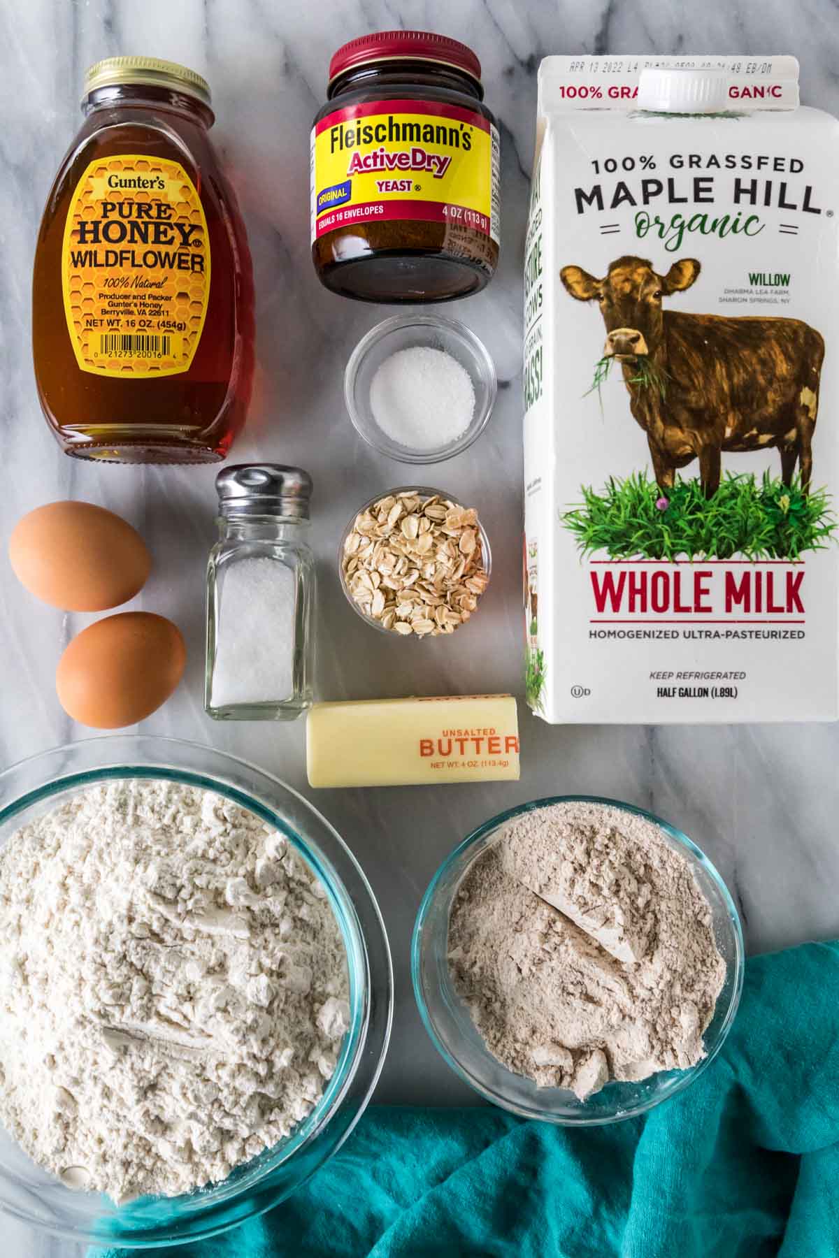 Overhead view of ingredients including honey, wheat flour, oats, and more.