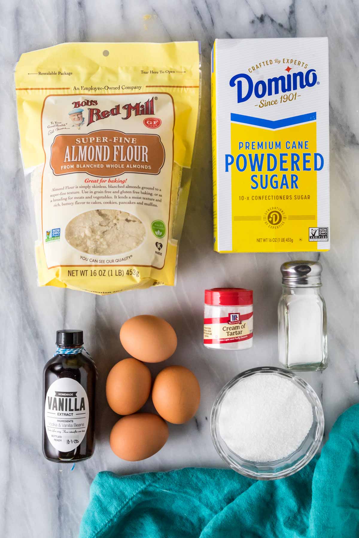 French macaron ingredients arranged on marble background