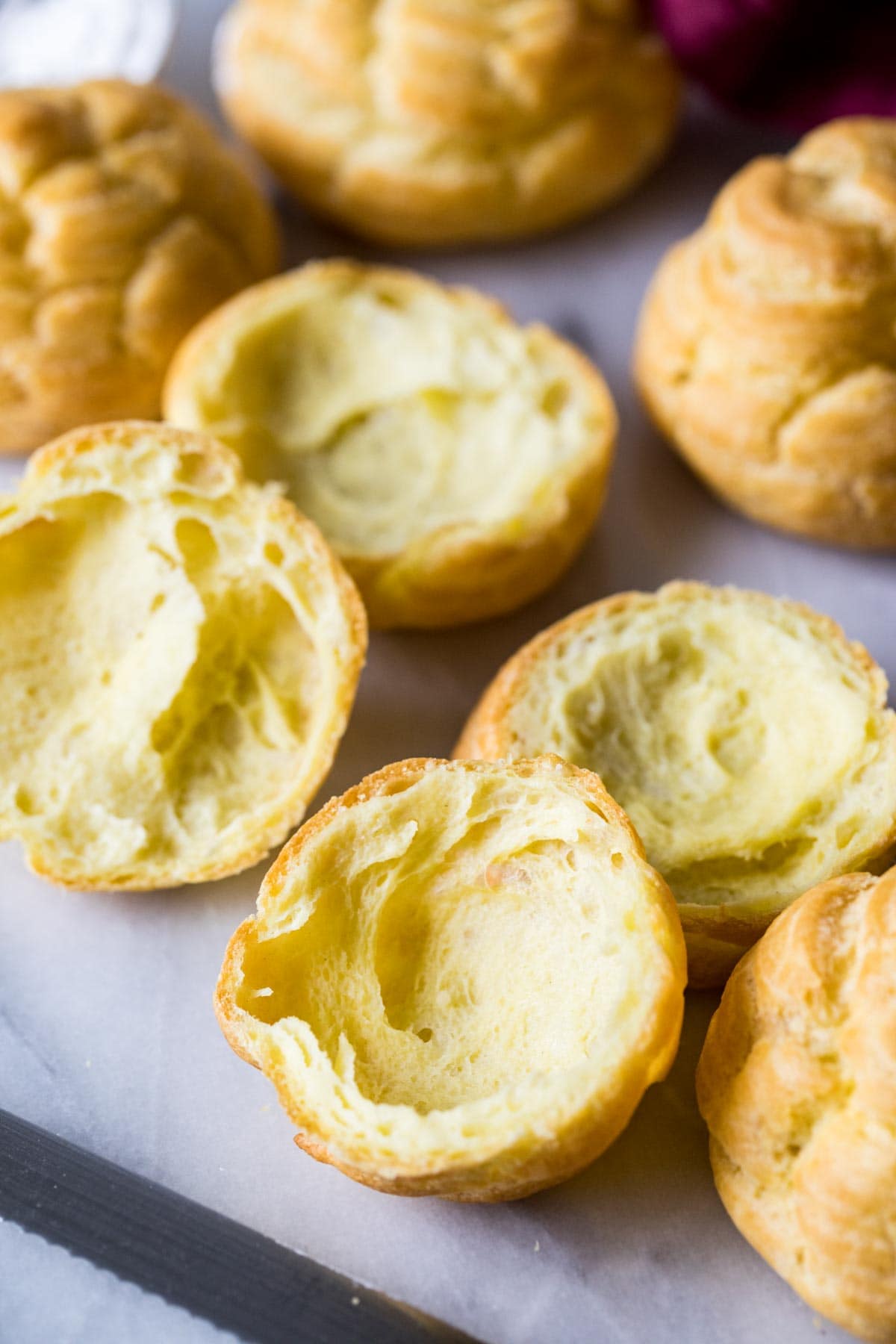Choux bun halves with rounded, airy interiors.