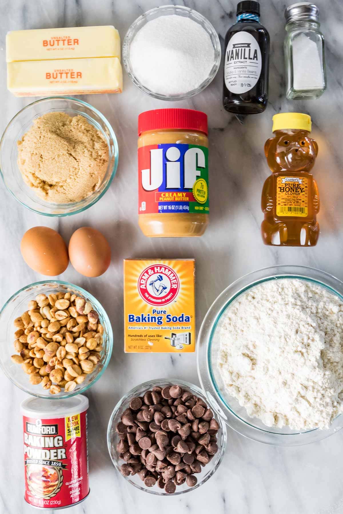 Overhead view of ingredients including honey, peanut butter, chocolate chips, peanuts, and more.