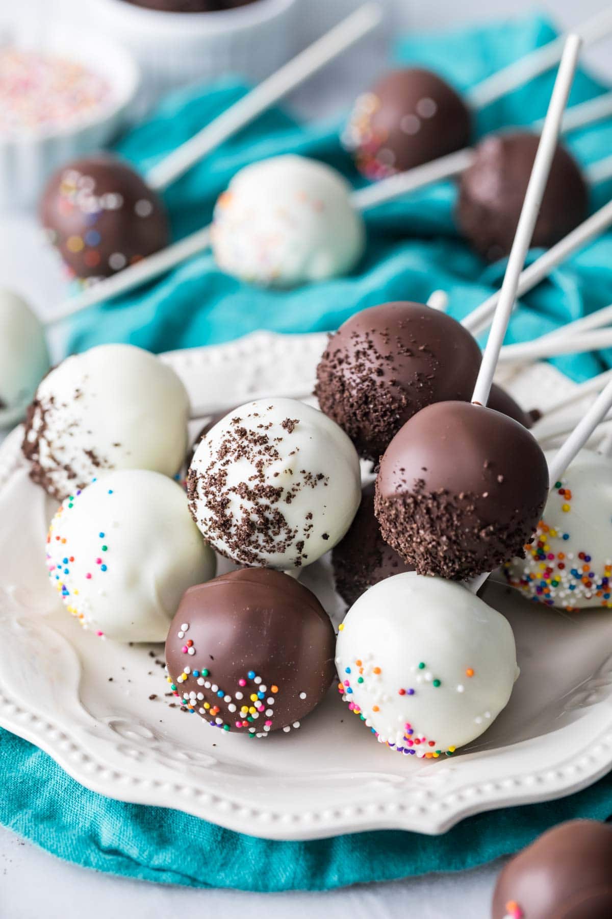 Cake pops coated in white and dark chocolate on a plate.