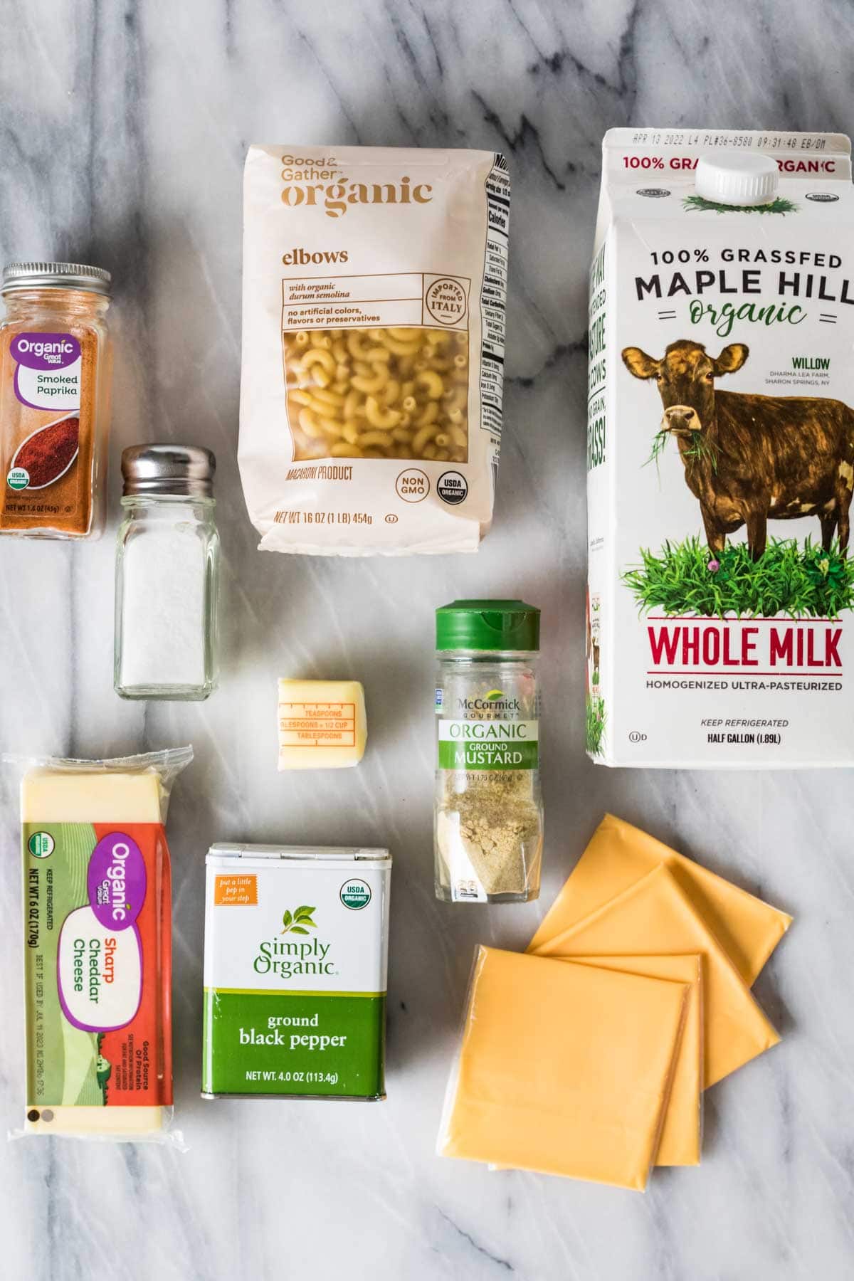 Overhead view of ingredients including macaroni, cheese slices, milk, and more.