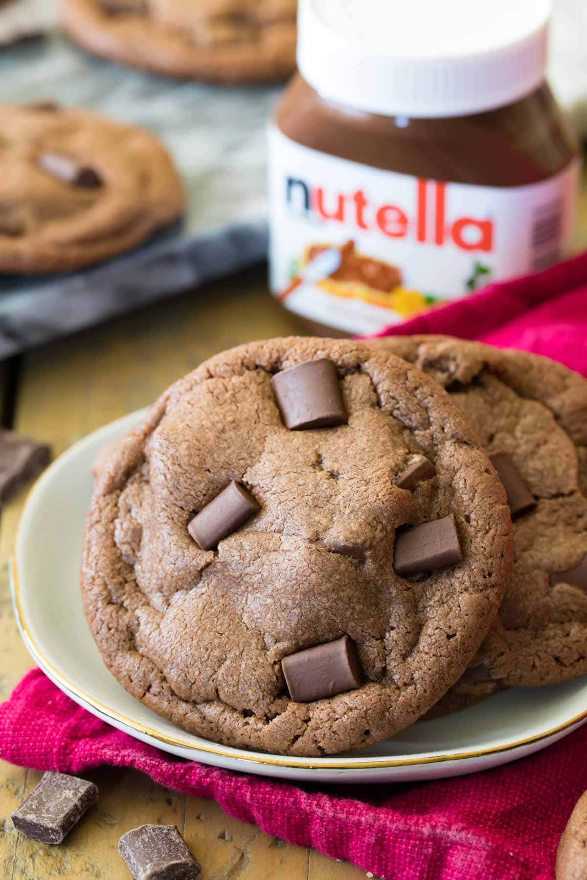 Nutella cookies on a plate with a jar of nutella in the background.