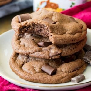 Stack of chocolatey nutella cookies with the top cookie missing one bite.