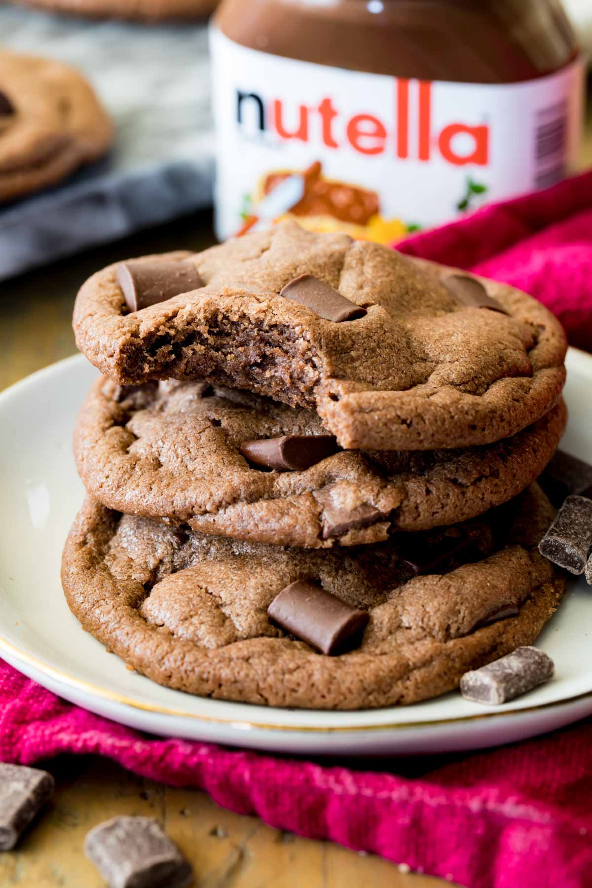 Stack of chocolatey nutella cookies with the top cookie missing one bite.