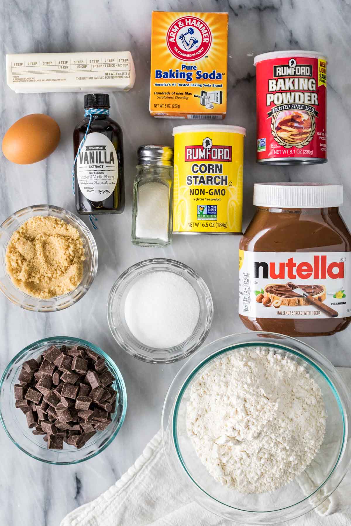 Overhead view of ingredients including nutella, chocolate chunks, flour, brown sugar, and more.