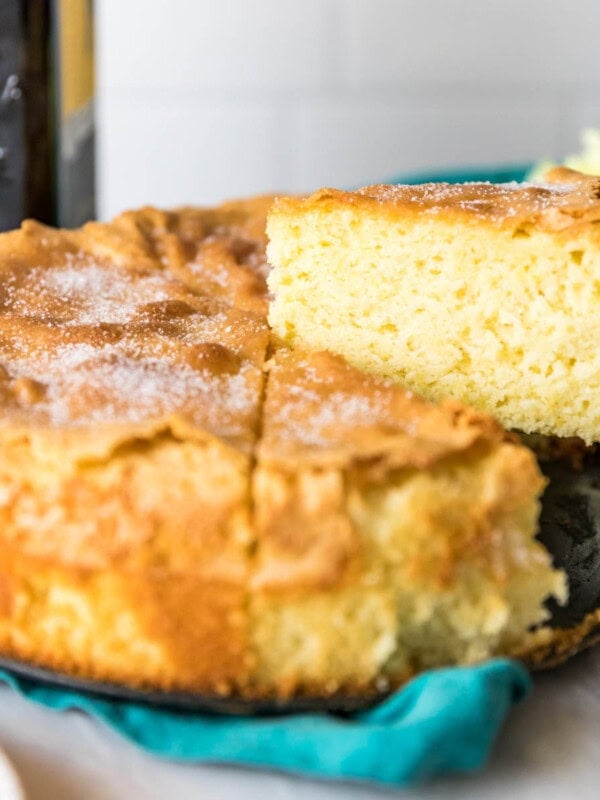 Slices being cut and served from an olive oil cake.