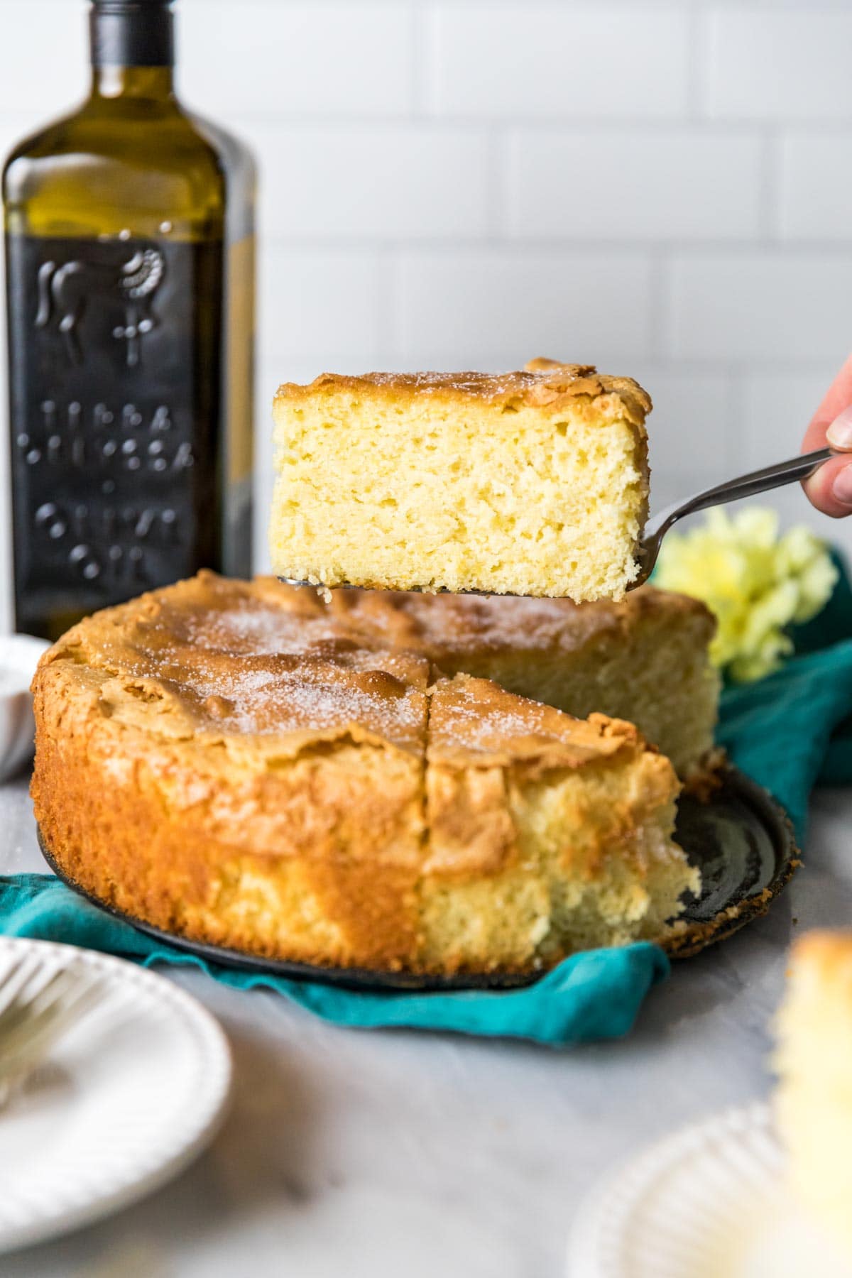 Slice of olive oil cake that has been cut from the whole cake and is about to be served.