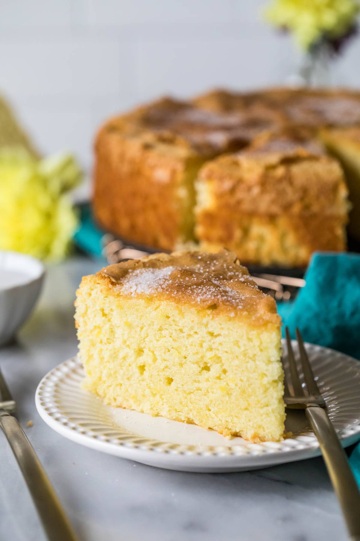 Slice of soft and dense olive oil cake on a plate.