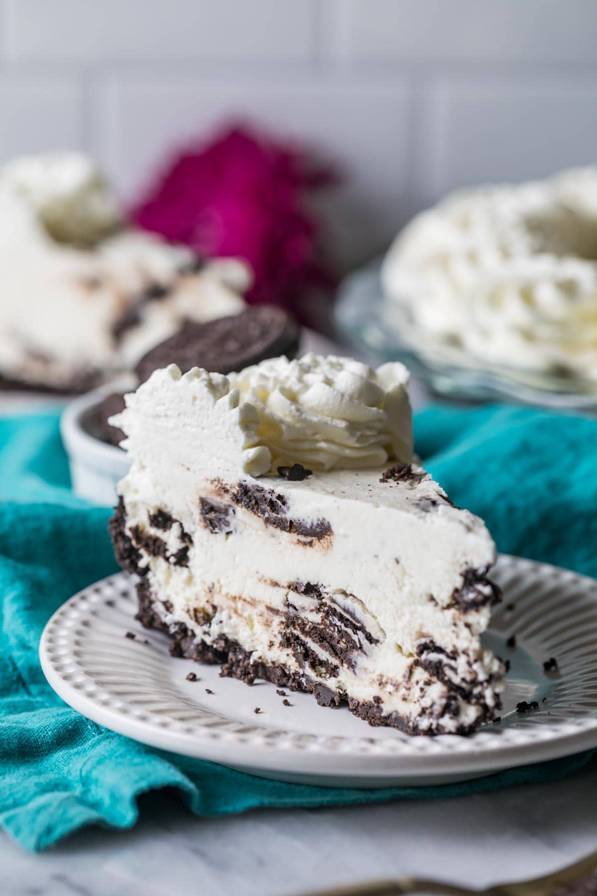 Tortenstück auf einem Teller mit Oreo-Kruste, Oreo-Cremefüllung und Schlagsahne-Topping.