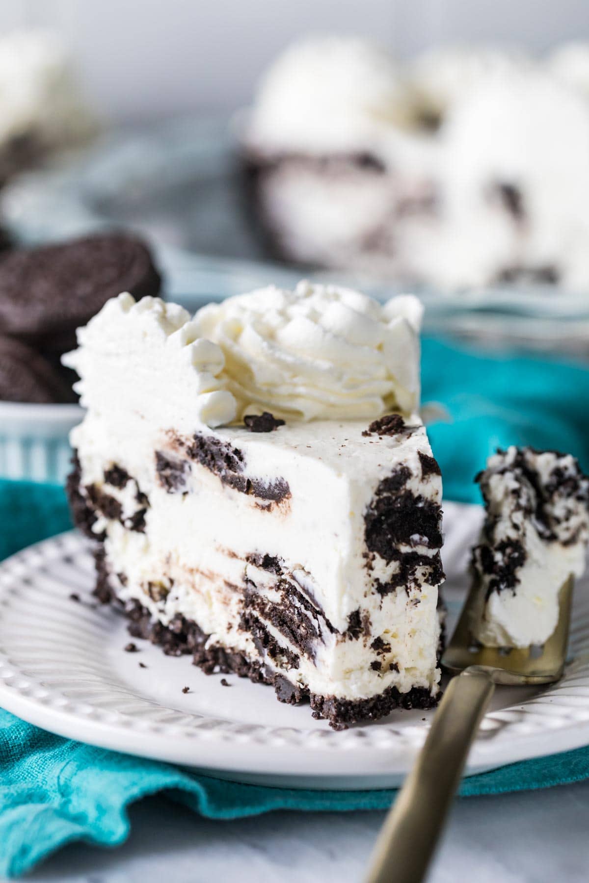 Ein Stück Oreo-Kuchen auf einem Teller, daneben eine Gabel, die den ersten Bissen hält.