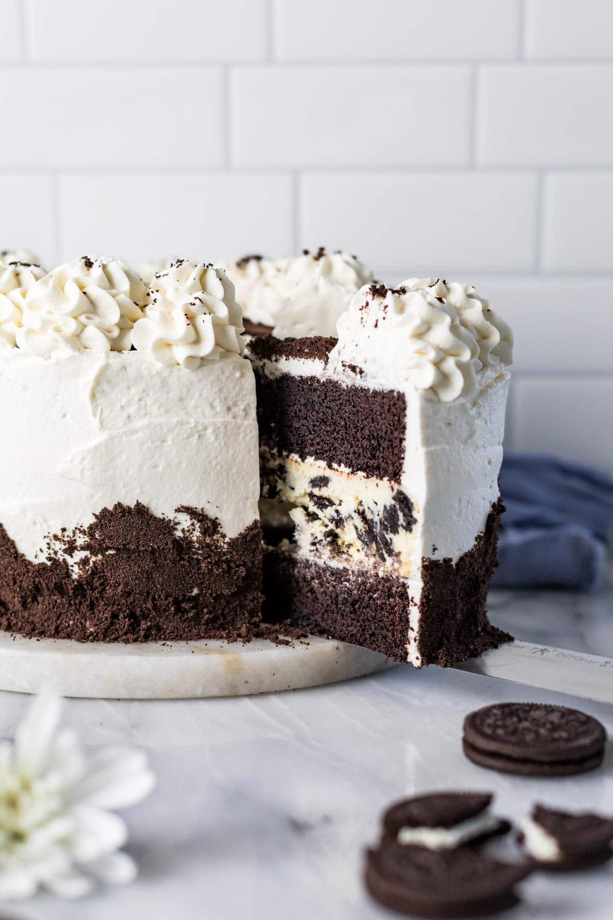 Slice of cake being cut from an oreo cheesecake cake.