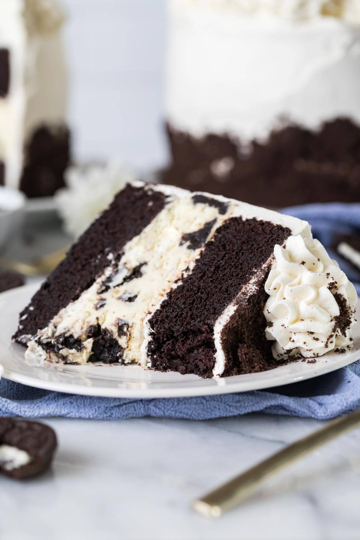 Slice of chocolate cake with an Oreo cheesecake filling missing a bite.