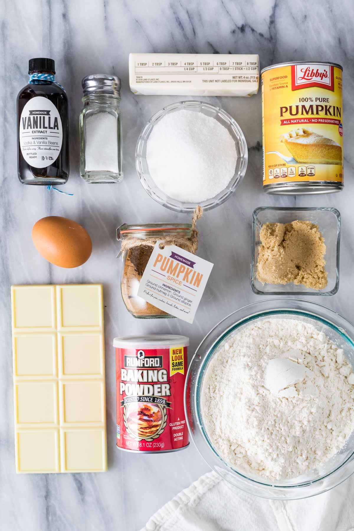 Overhead view of ingredients including pumpkin, white chocolate, butter, flour, and more.