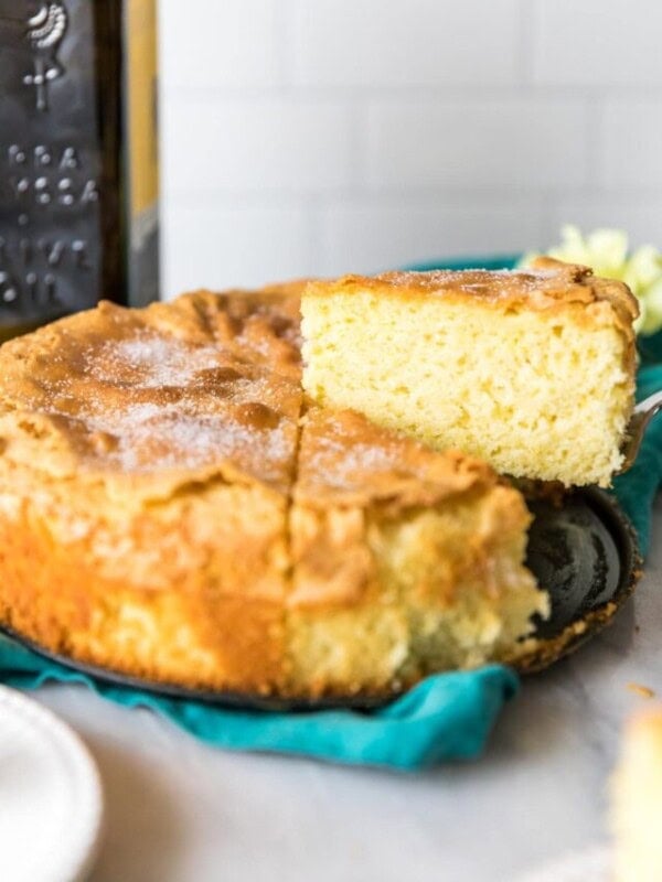 Slices being cut and served from an olive oil cake.