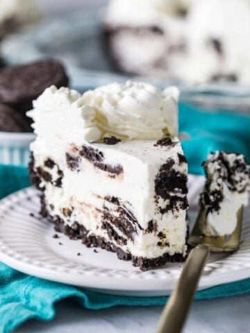 Slice of Oreo pie on a plate with a fork beside it holding the first bite.