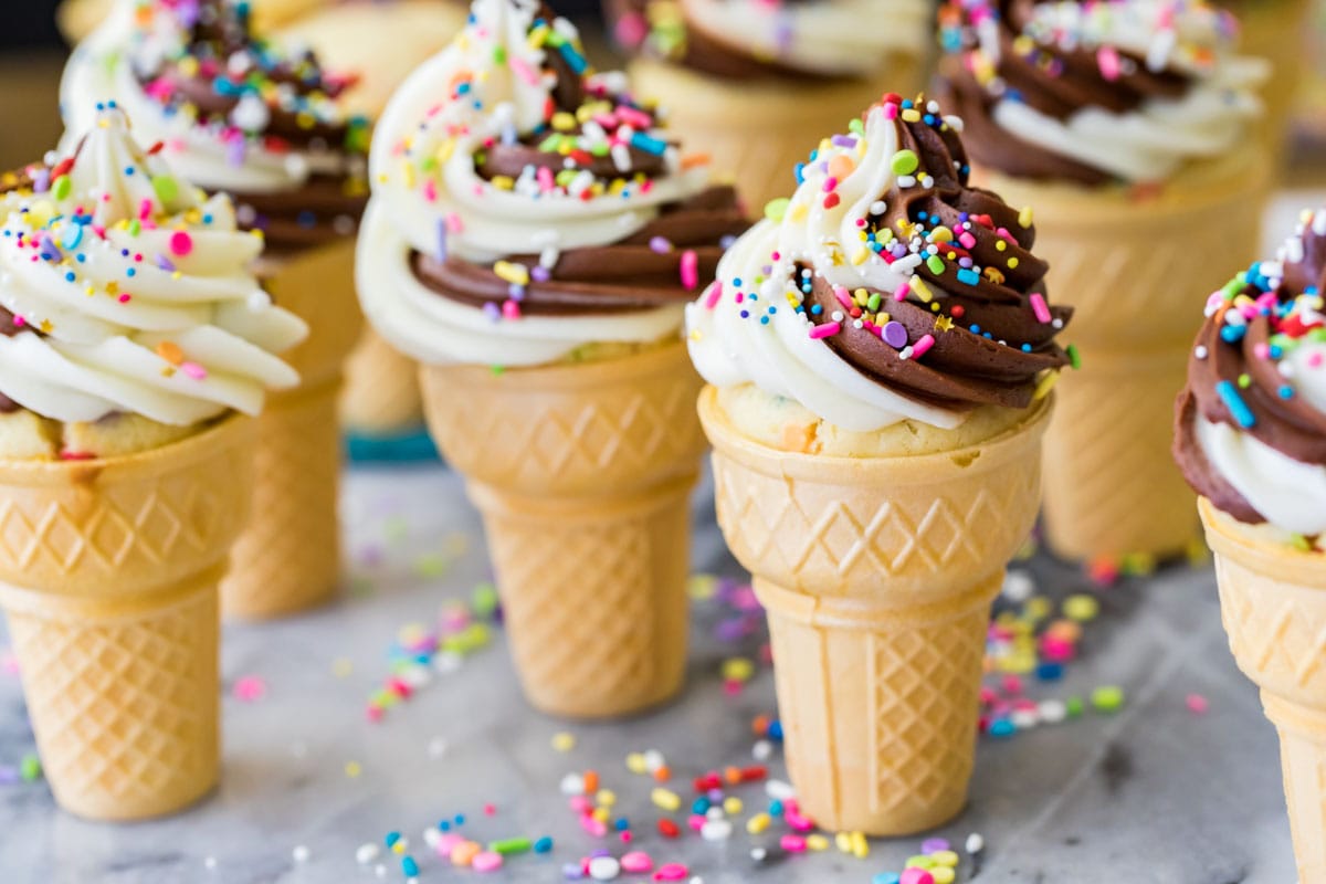 Ice cream cone cupcakes topped with a chocolate vanilla frosting swirl and sprinkles.