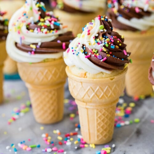 Ice cream cone cupcakes topped with a chocolate vanilla frosting swirl and sprinkles.