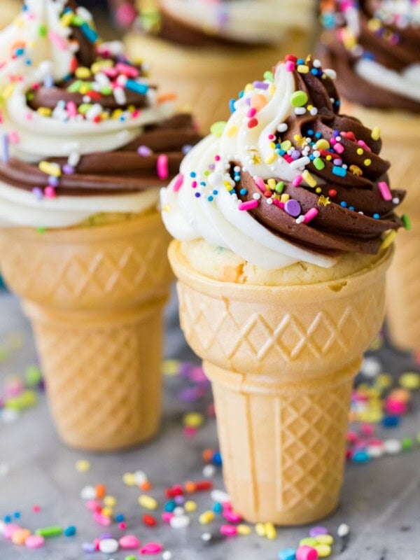 Ice cream cone cupcakes topped with a chocolate vanilla frosting swirl and sprinkles.