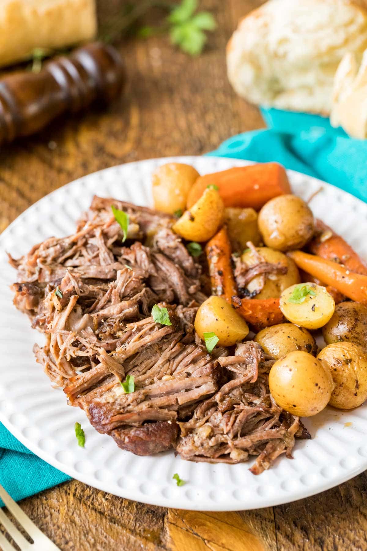 Plate of beef pot roast with baby potatoes and carrots.