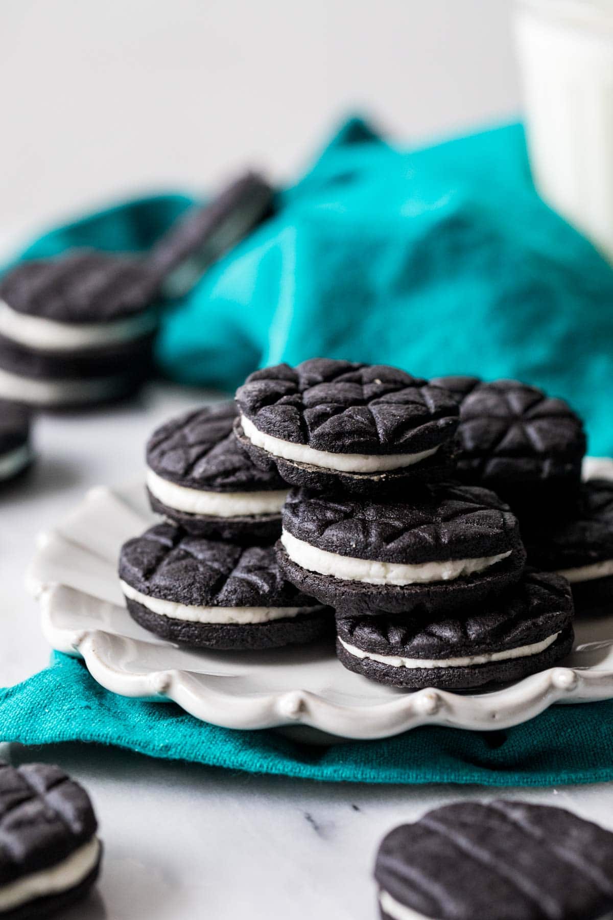 White plate with black and white sandwich cookies stacked on top.