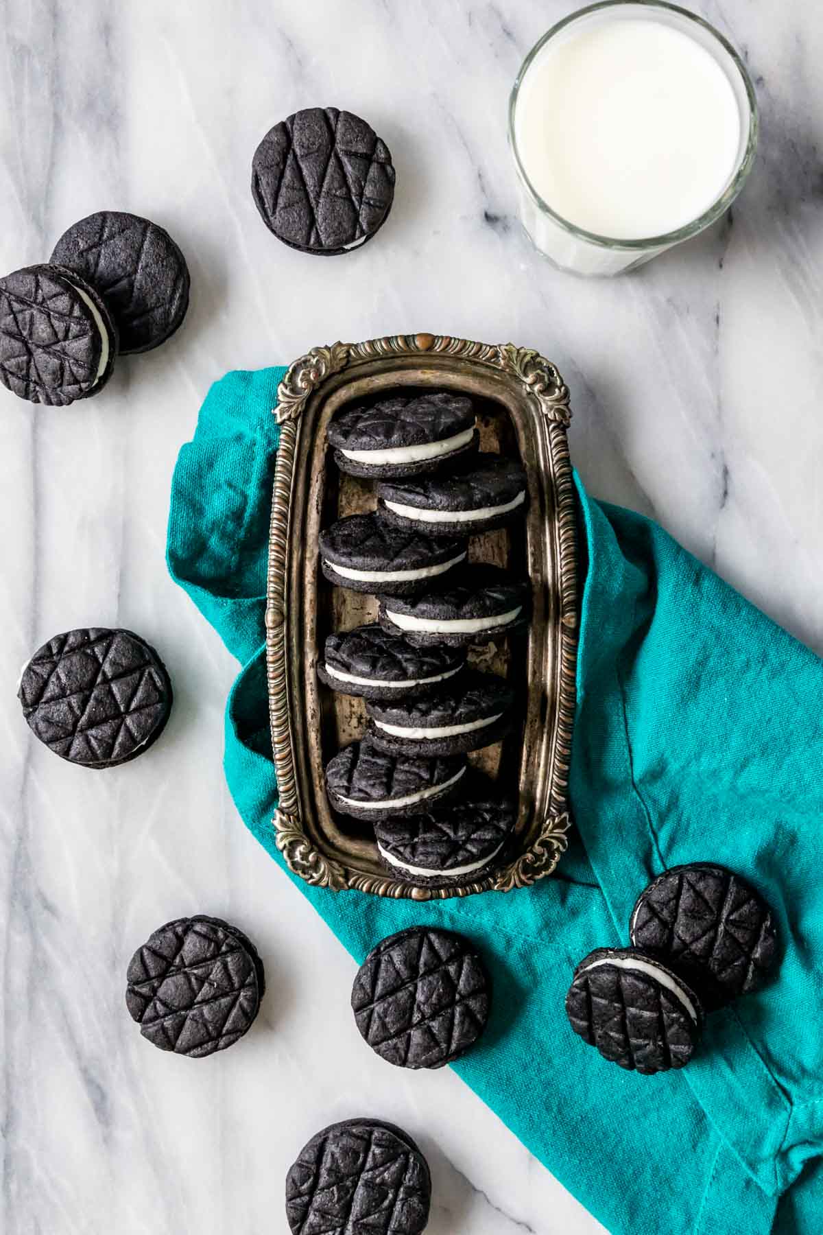 Overhead view of a silver tray with homemade Oreos staggered on top.