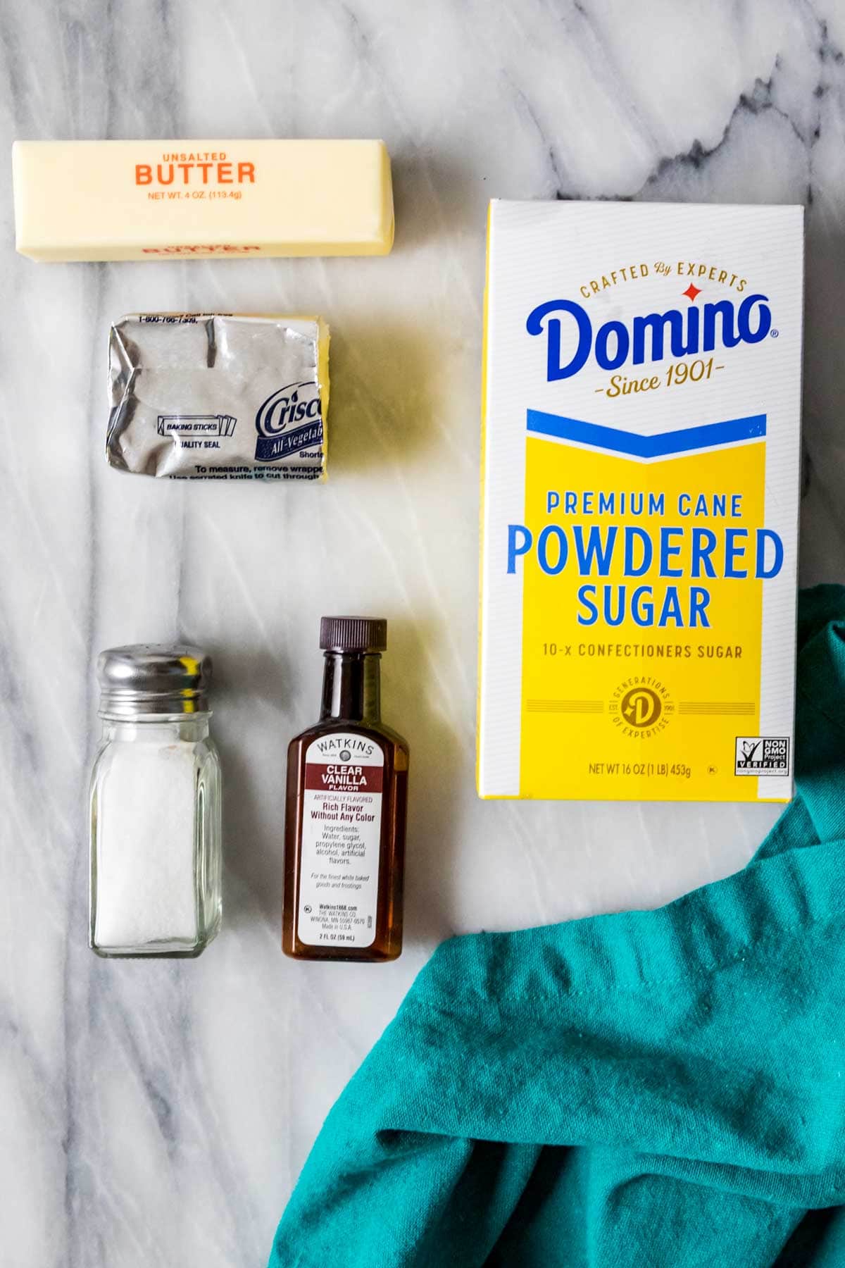 Overhead view of ingredients including powdered sugar, shortening, vanilla, salt, and butter.