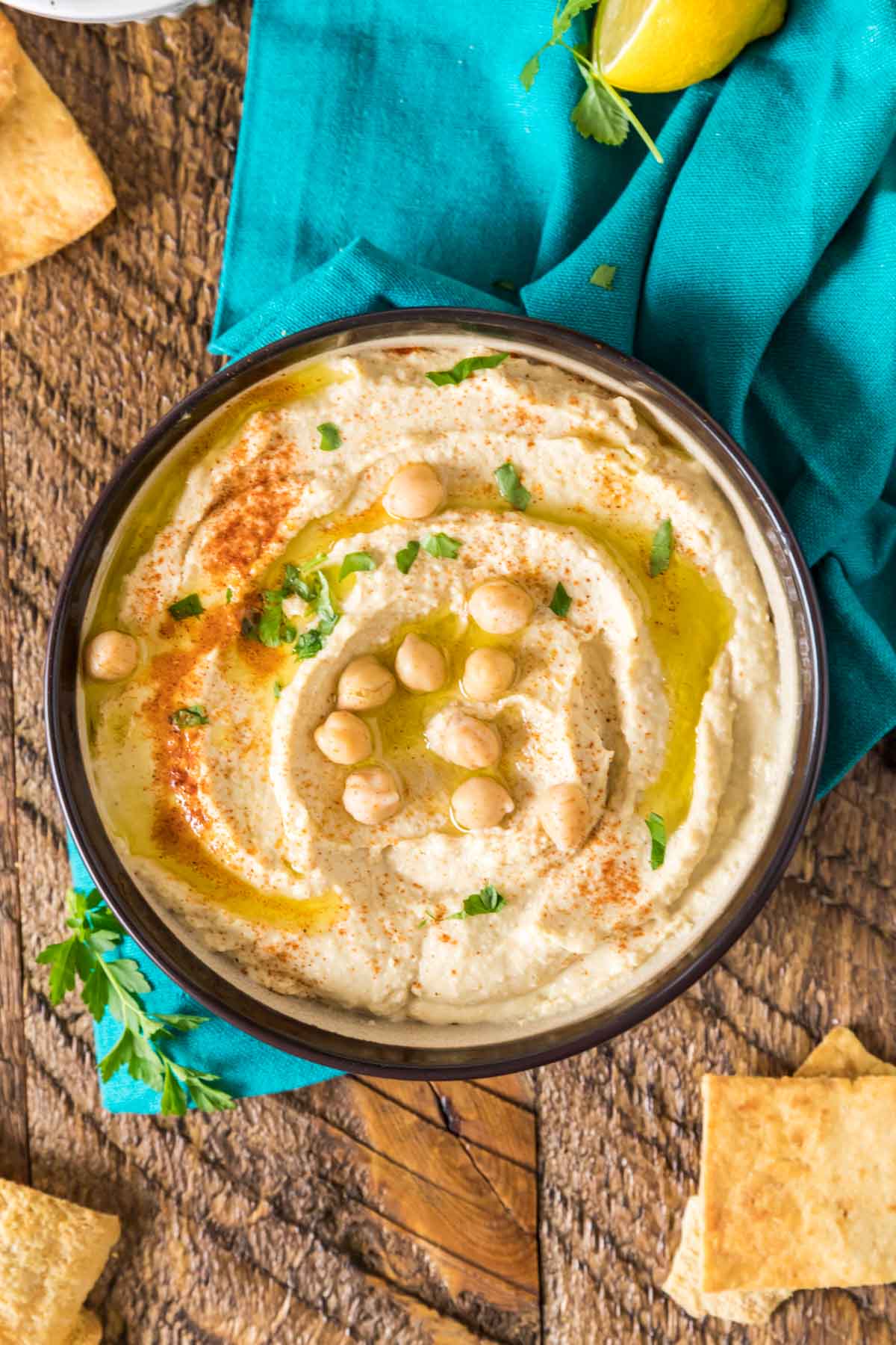 Overhead view of a bowl of chickpea dip topped with olive oil, paprika, and parsley.