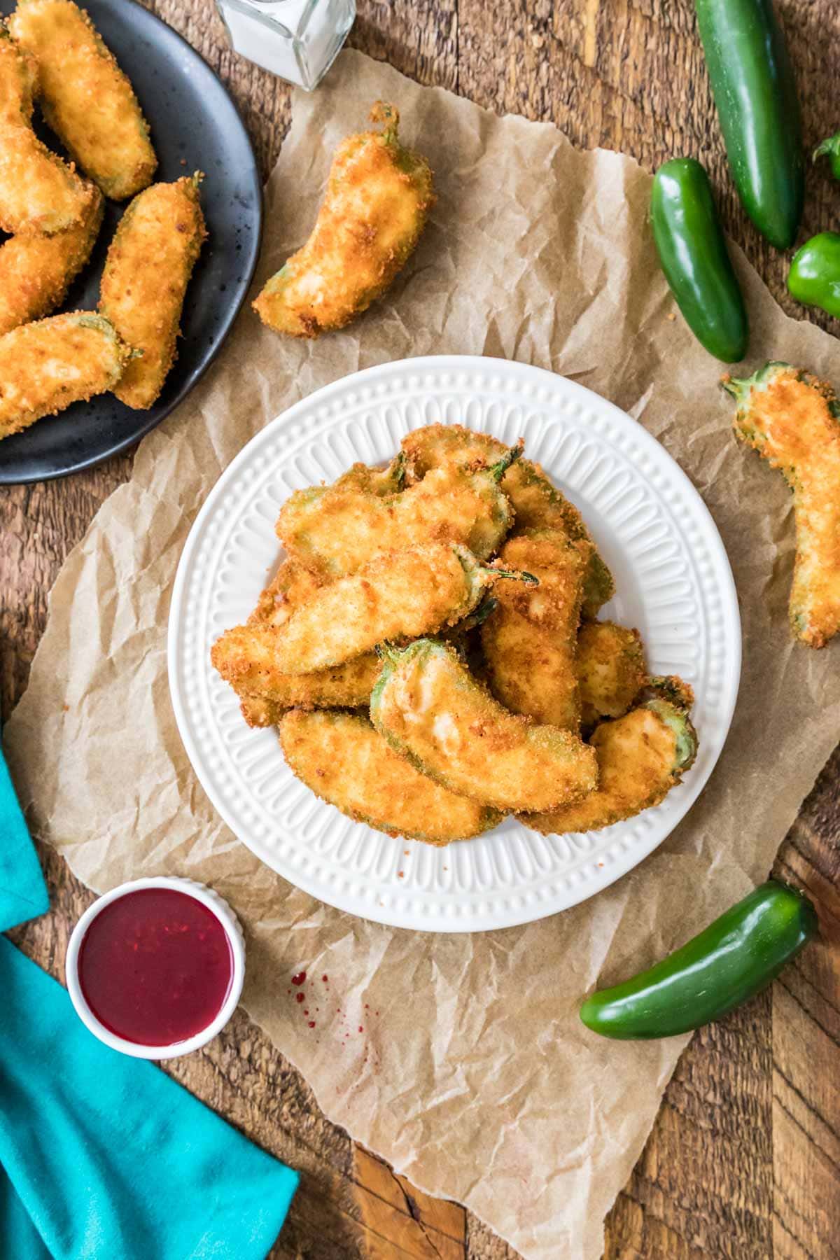 Overhead view of a plate of breaded stuffed jalapenos.