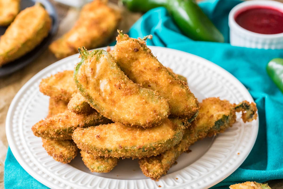 Plate of jalapeno poppers stacked on top of each other.